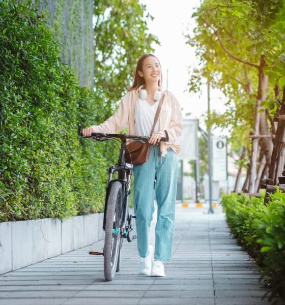 ragazza che cammina con la bicicletta per mano