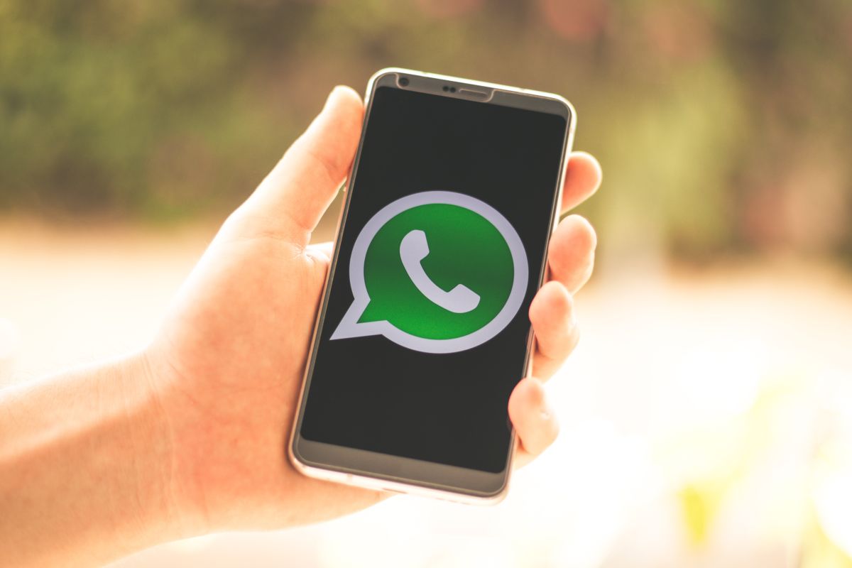 Mano che tiene in mano uno smartphone con aperto whatsapp