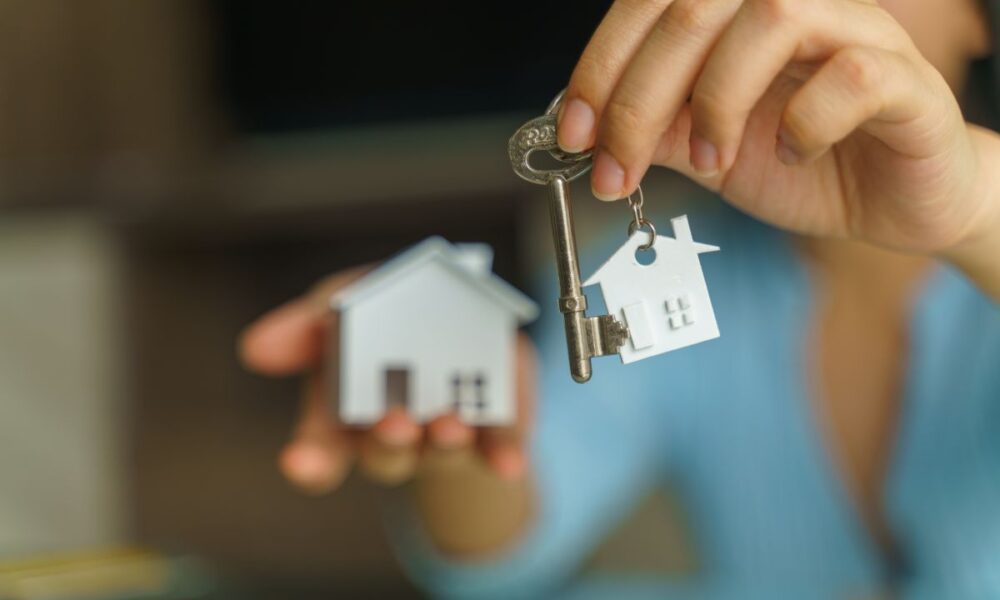 Ragazza che tiene in mano le chiavi della sua casa in affitto