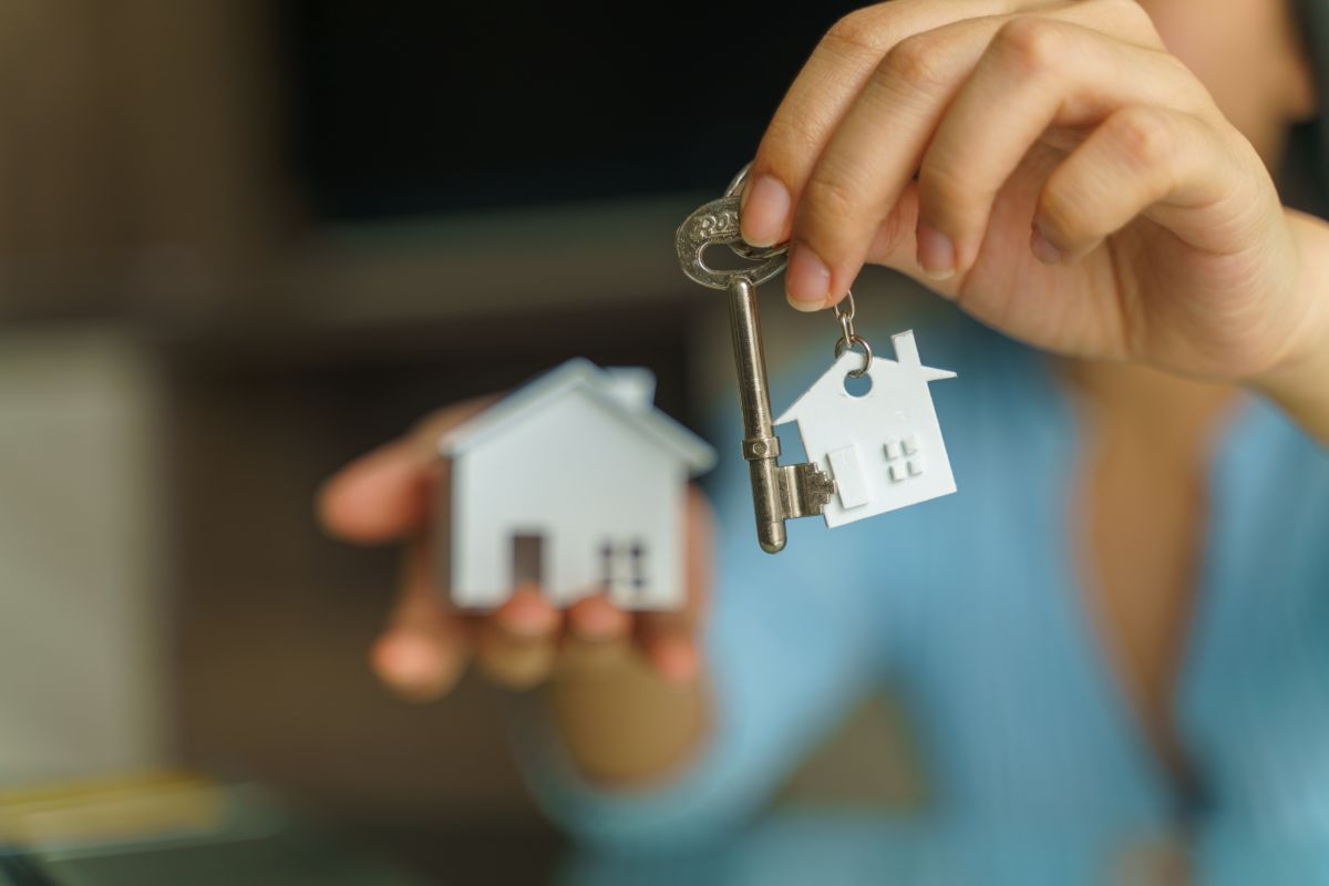 Ragazza che tiene in mano le chiavi della sua casa in affitto