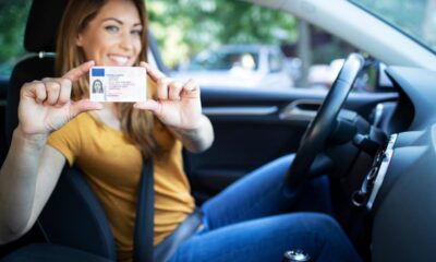 Ragazza felice ce tiene in mano la patente nella sua auto