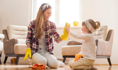 Mamma che gioca con la figlia facendo le pulizie di casa