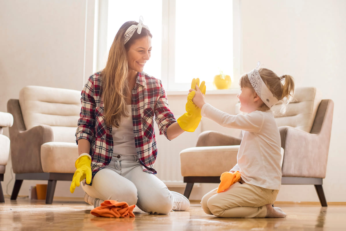 Mamma che gioca con la figlia facendo le pulizie di casa