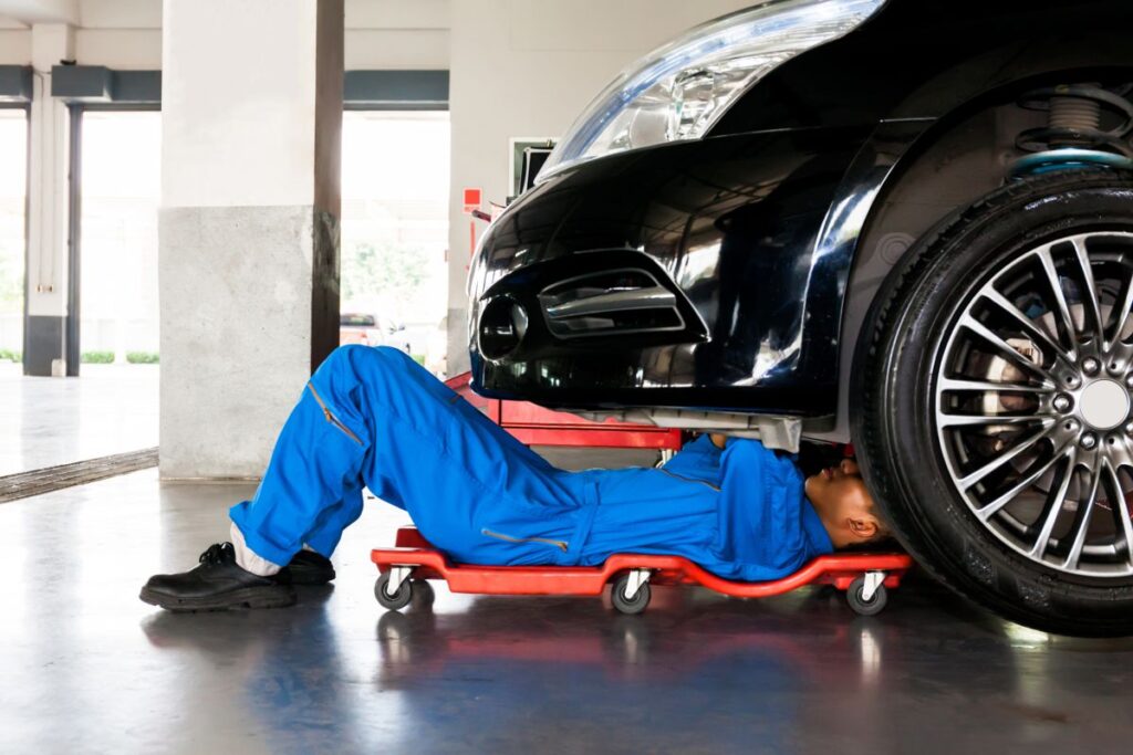 Meccanico che fa la revisione ad un auto in officina