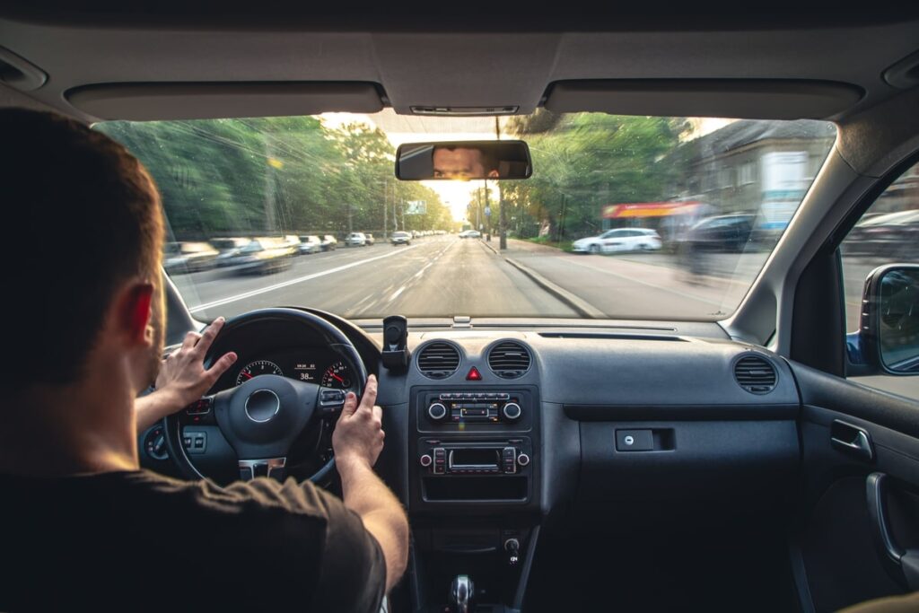 Persona che guida la sua auto su una strada libera 