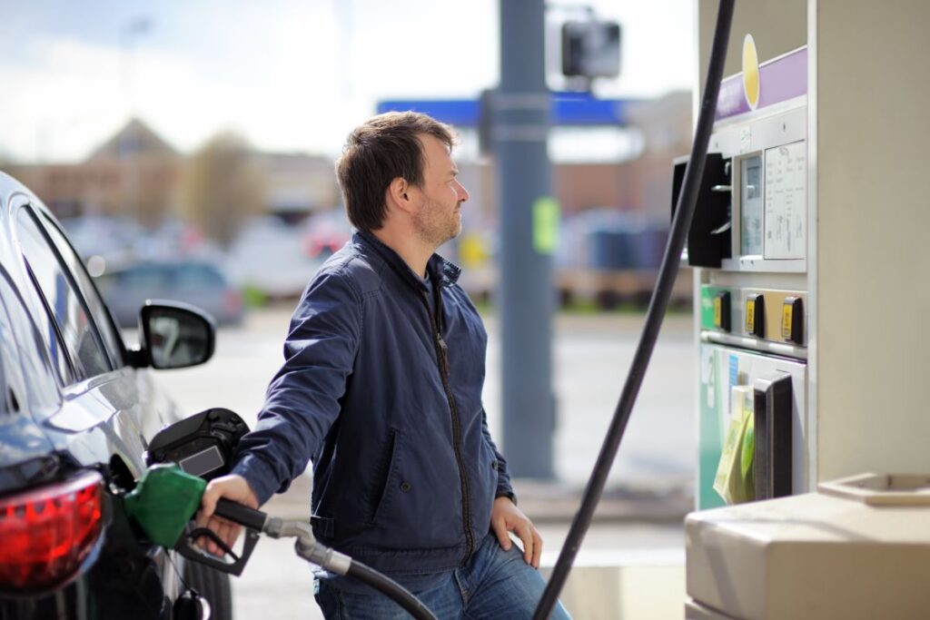 Uomo che fa benzina alla propria auto ad un distributore self-service