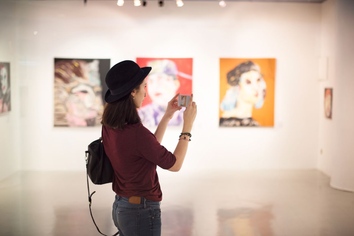 Ragazza in un museo che fa delle foto alle opere