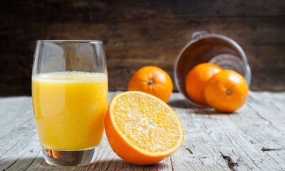 Bicchiere di succo d'arancia con degli aranci sul tavolo