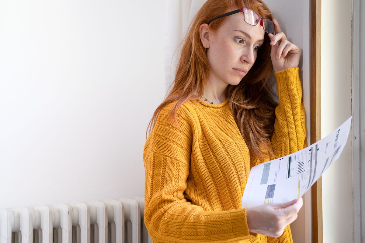 Ragazza che guarda preoccupata la bolletta